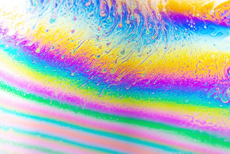 Vivid abstract close-up of a colorful soap bubble showing swirling patterns.