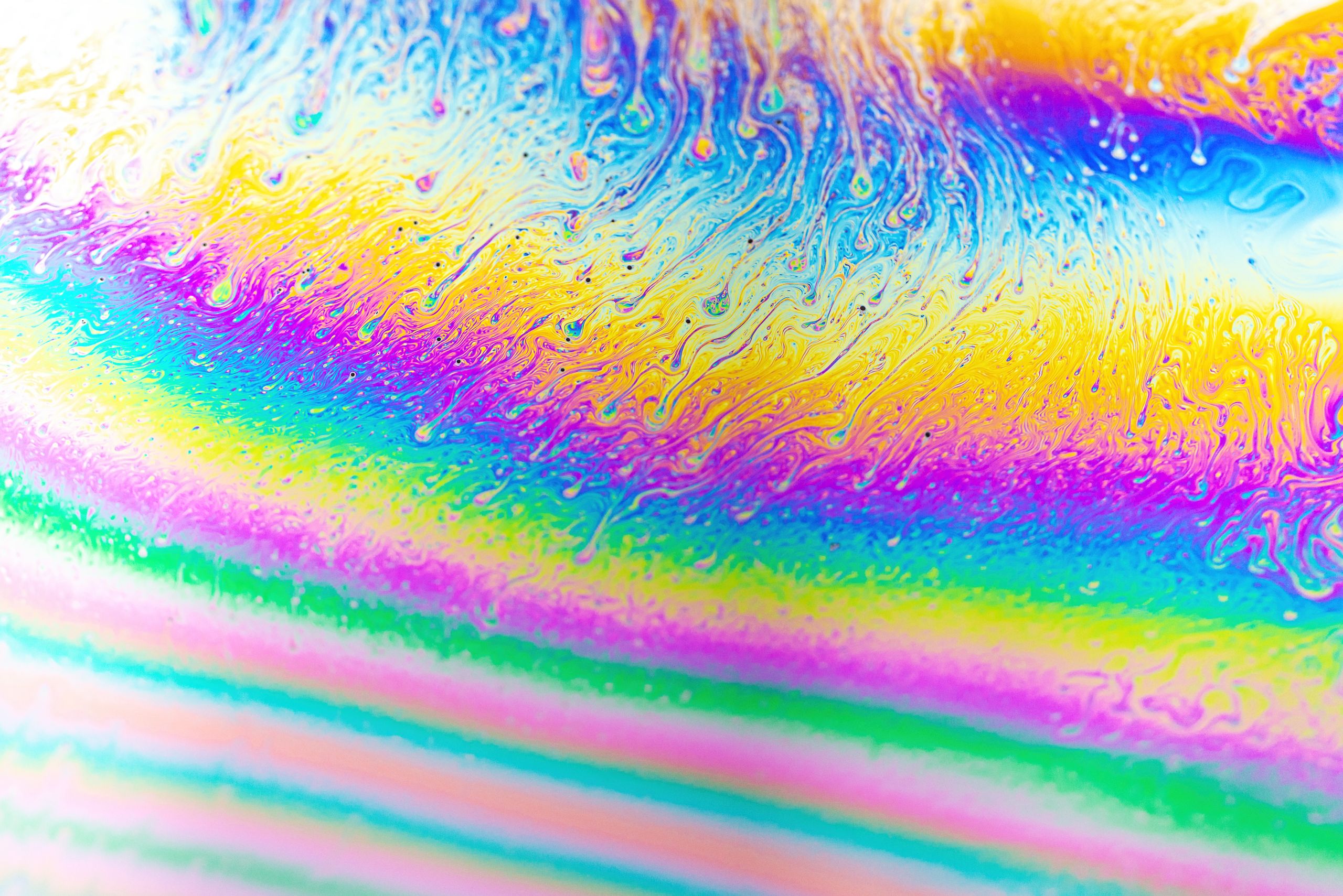 Vivid abstract close-up of a colorful soap bubble showing swirling patterns.